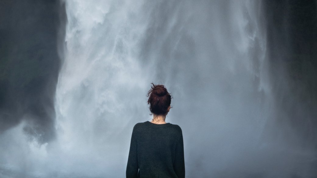 Bak á konu, horfir á Seljalandsfoss